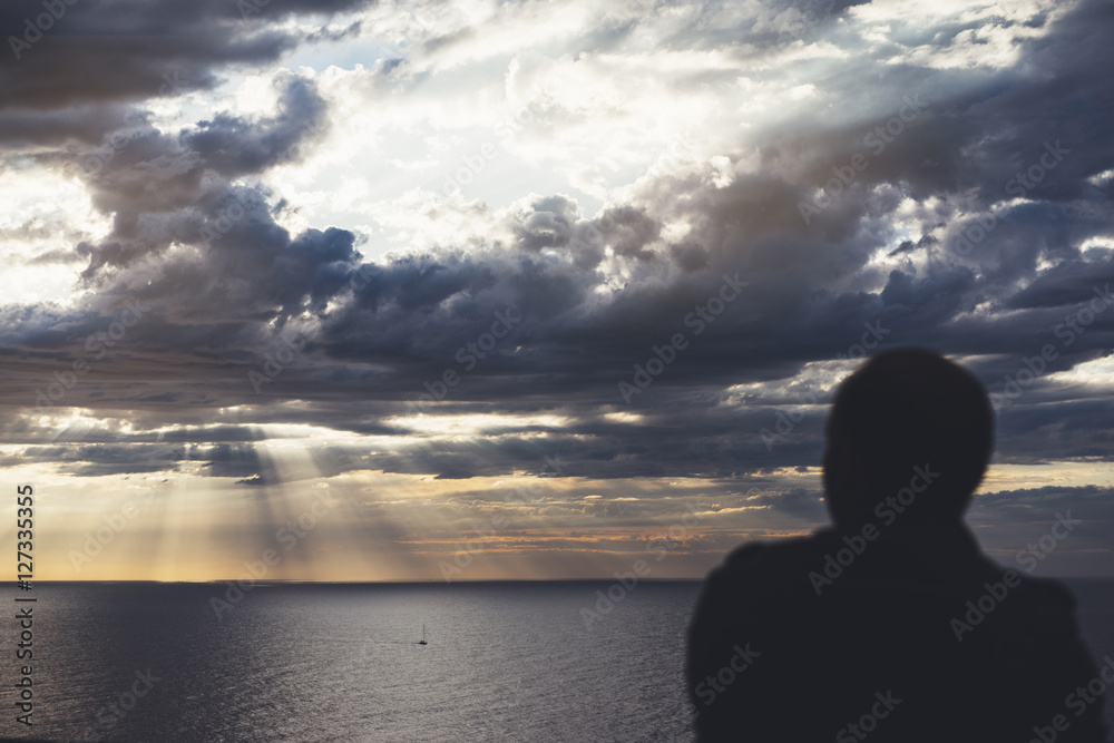 Clouds blue sky and sunlight sunset on horizon ocean Northern Spain. Outline looking travel hipster on background seascape dramatic rays sunrise. Relax view waves sea, mockup nature concept.