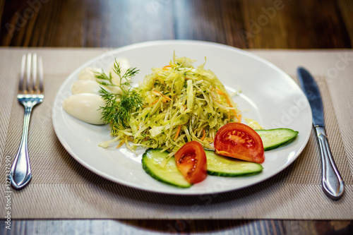 Salad with fresh cabbage are served with eggs and vegetables,restaurant, serving meals in a restaurant, proper nutrition