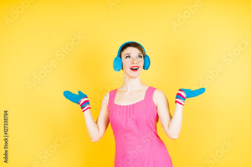 Young beautiful woman in dress and gloves on yellow background.