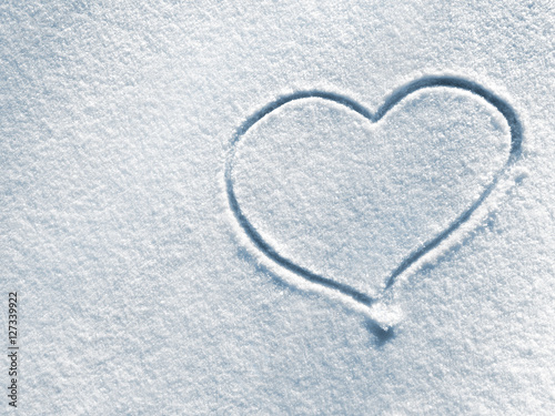 Closeup symbol of heart on the background of fresh snow texture in blue tone. Merry Christmas or Valentine s Day Concept. Top view  high resolution product