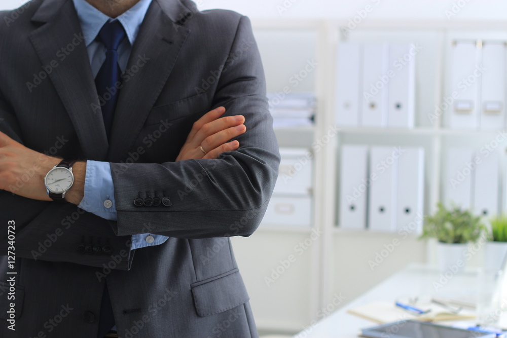 Fototapeta premium Businessman standing with arms crossed in office