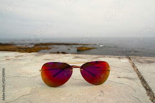 Sunglasses on a stone parapet on the seashore