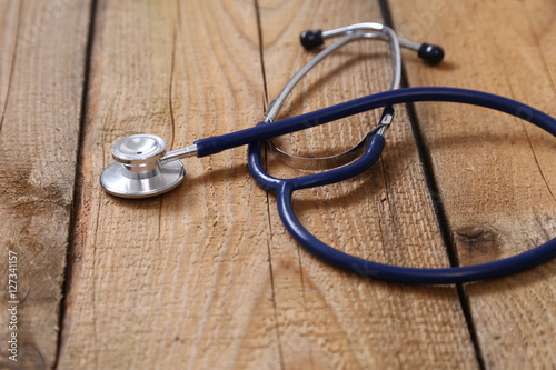 Closeup of a medical stethoscope, isolated on wooden background