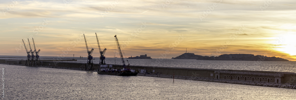 panorama sur une digue devant le port de Marseille, au coucher de soleil, depuis les terrasses du port