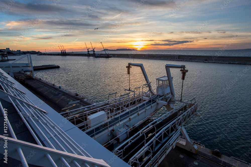 une digue devant le port de Marseille, au coucher de soleil, depuis les terrasses du port une digue devant le port de Marseille, au coucher de soleil, depuis les terrasses du port