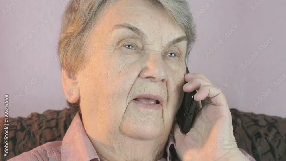 Elderly woman talks on smartphone with smile Elderly woman talks on smartphone with smile