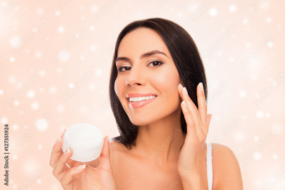 Young attractive girl applying cream on her face, xmas concept Young attractive girl applying cream on her face, xmas concept