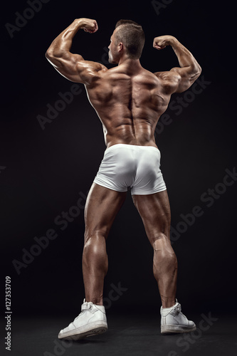 Strong Athletic Man Fitness Model posing back muscles, triceps,