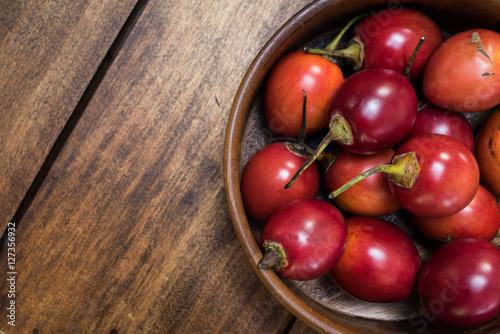 tomate de árbol - Tamarillo - Frutas exóticas del trópico sobre fondo de madera natural - toma de estudio desde arriba - luz natural photo