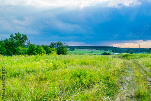 Storm sky under a summer meadow at the Urals