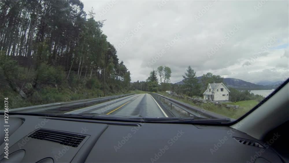 View of the road out of the car.  Building. Shops, Forest. oncoming traffic