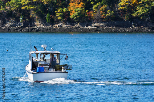 Lobster fishing boat in autumn against deep blue ocean water in coastal Maine, New England