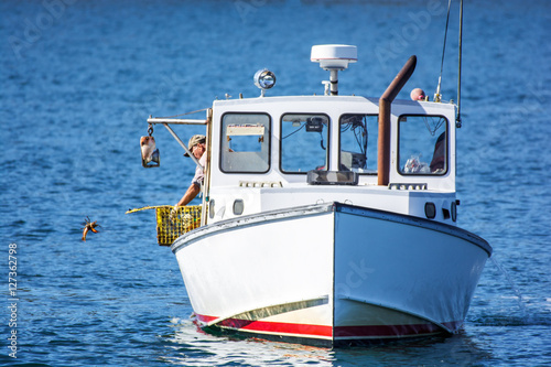 Lobster fishing boat in autumn against deep blue ocean water in coastal Maine, New England