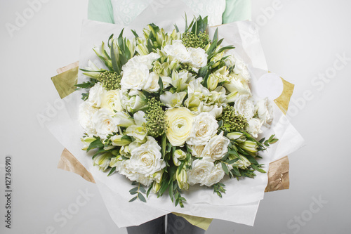 rich bouquet flowers of different colors mixed in woman hand .
