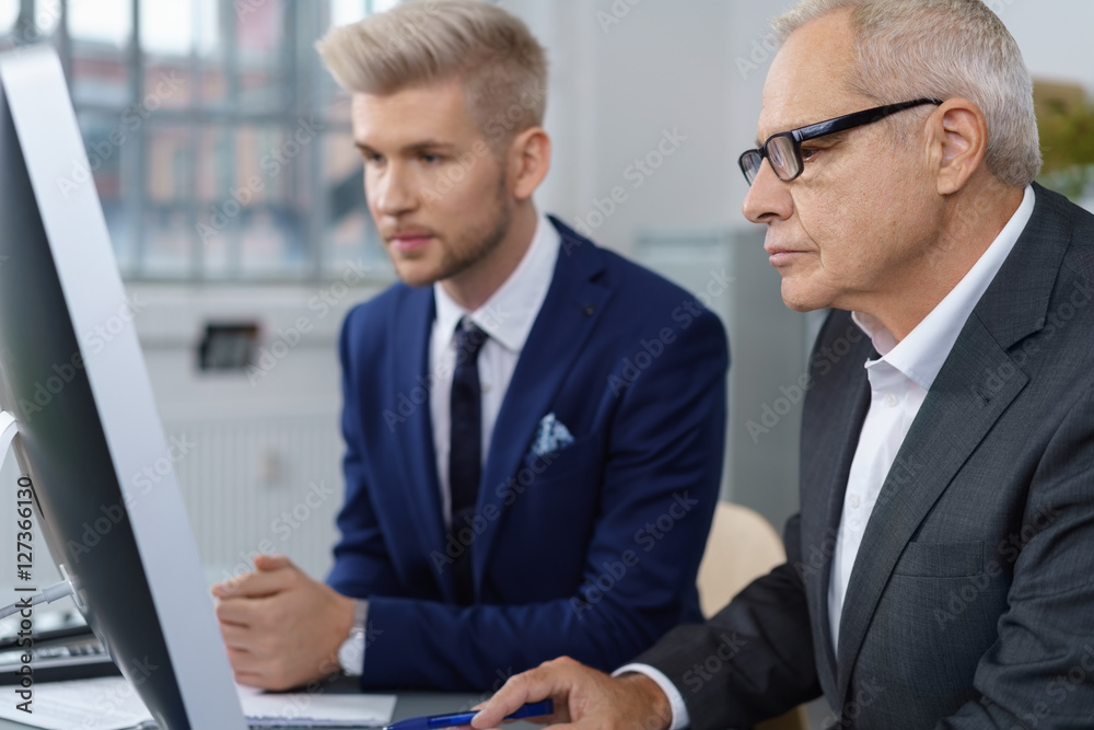 vater und sohn arbeiten zusammen im unternehmen am computer vater und sohn arbeiten zusammen im unternehmen am computer