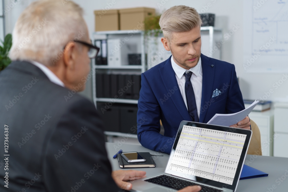zwei männer im büro arbeiten zusammen und schauen auf unterlagen zwei männer im büro arbeiten zusammen und schauen auf unterlagen