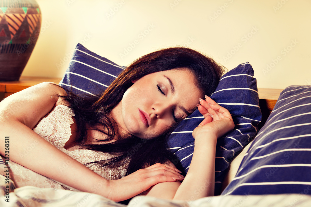 Young woman sleeping on the white bedclothes in bed Stock Photo