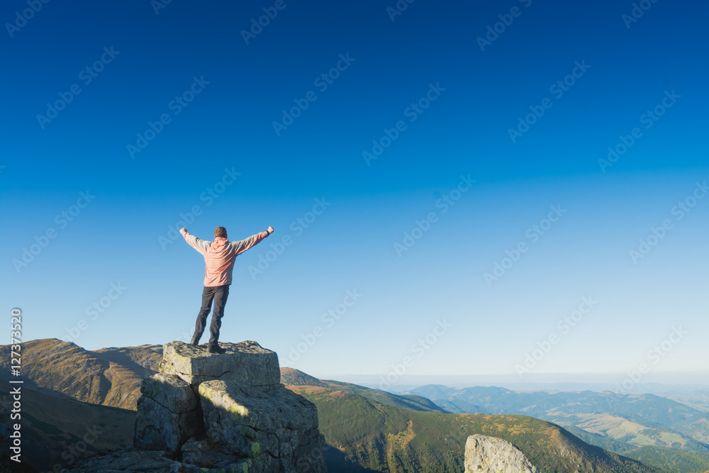 Winner man standing on a cliffs edge Winner man standing on a cliffs edge