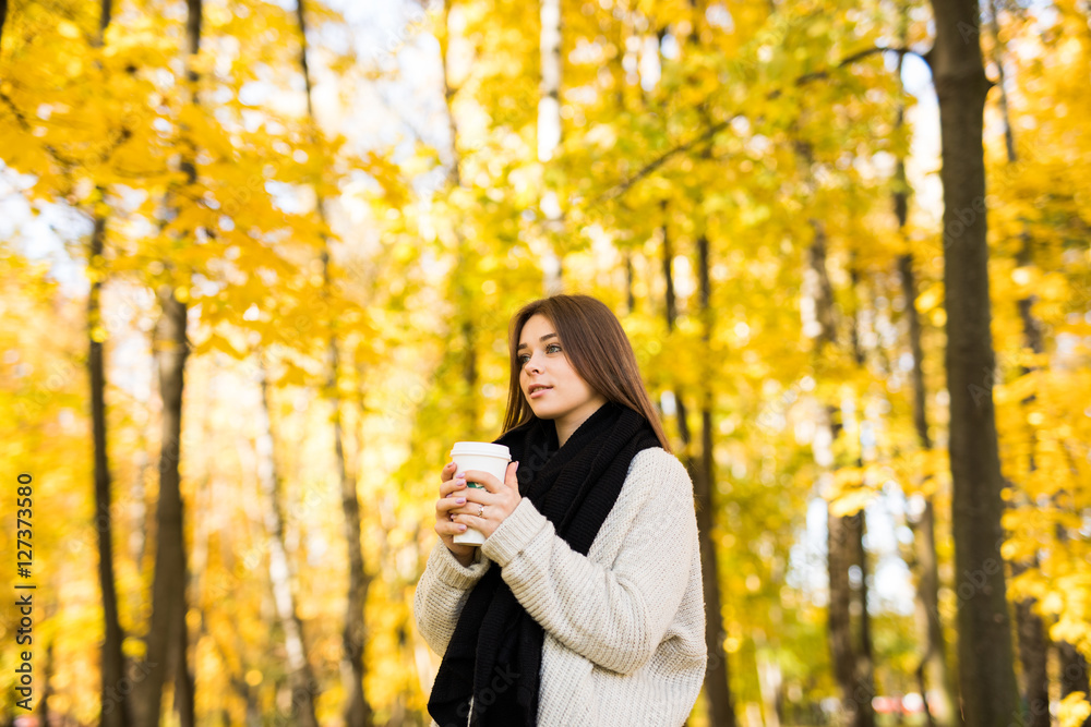 Young girl drink coffee in autumn yellow sunny park Young girl drink coffee in autumn yellow sunny park