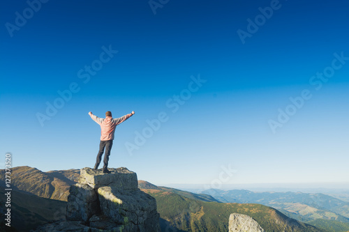 Winner man standing on a cliffs edge