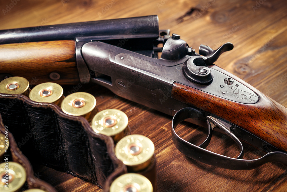 Obraz premium Shotgun with shells on wooden background