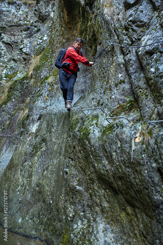 Man hiker climbing mountain walls