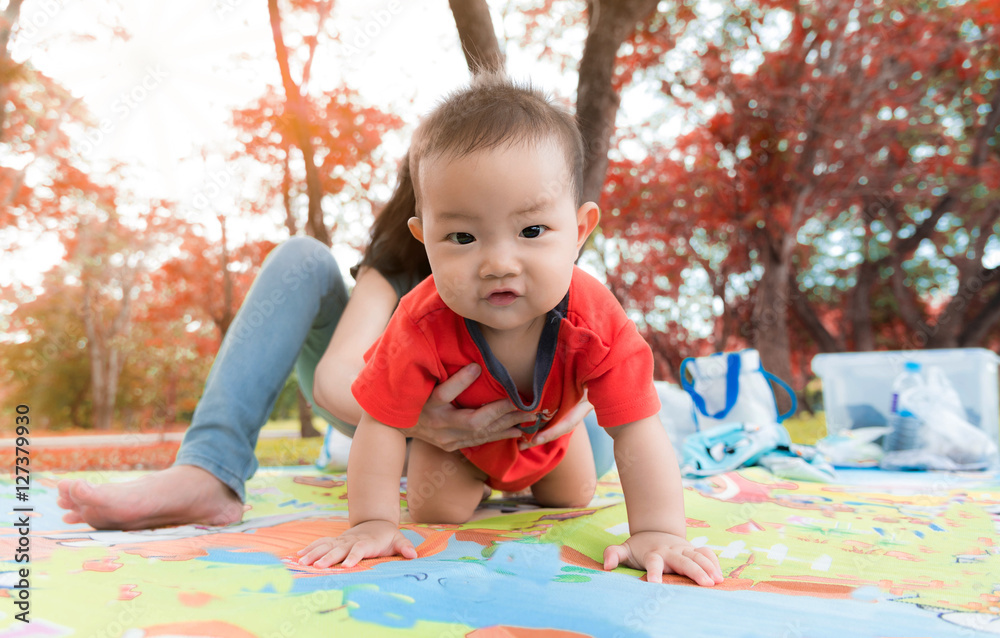Happiness asia mother and baby having a picnic outdoor in the pa Happiness asia mother and baby having a picnic outdoor in the pa