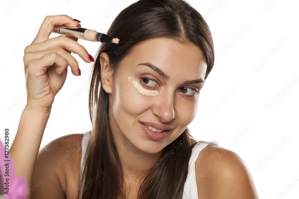 young women applied concealer under the eyes with applicator young women applied concealer under the eyes with applicator