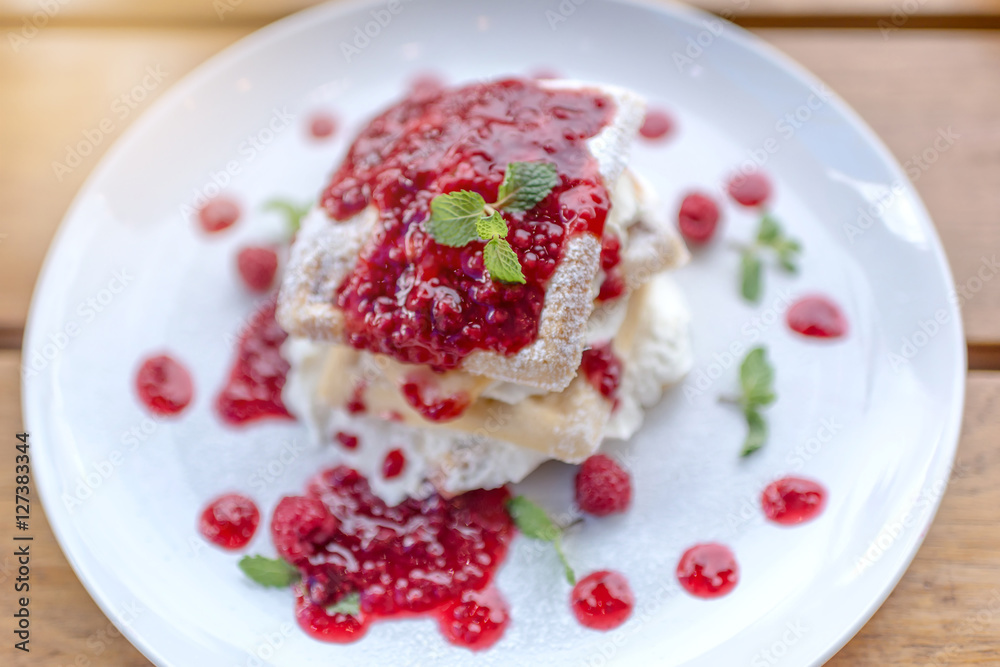 waffles with raspberries on wooden table, selective focus, lights effects. waffles with raspberries on wooden table, selective focus, lights effects.