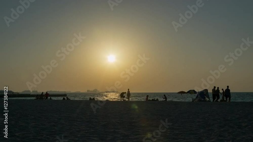 People walk in the evening on the beach photo