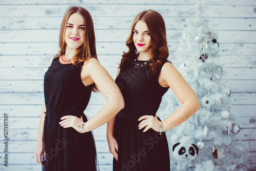 happy and beautiful sisters in black dresses standing near the C © pyrozenko13