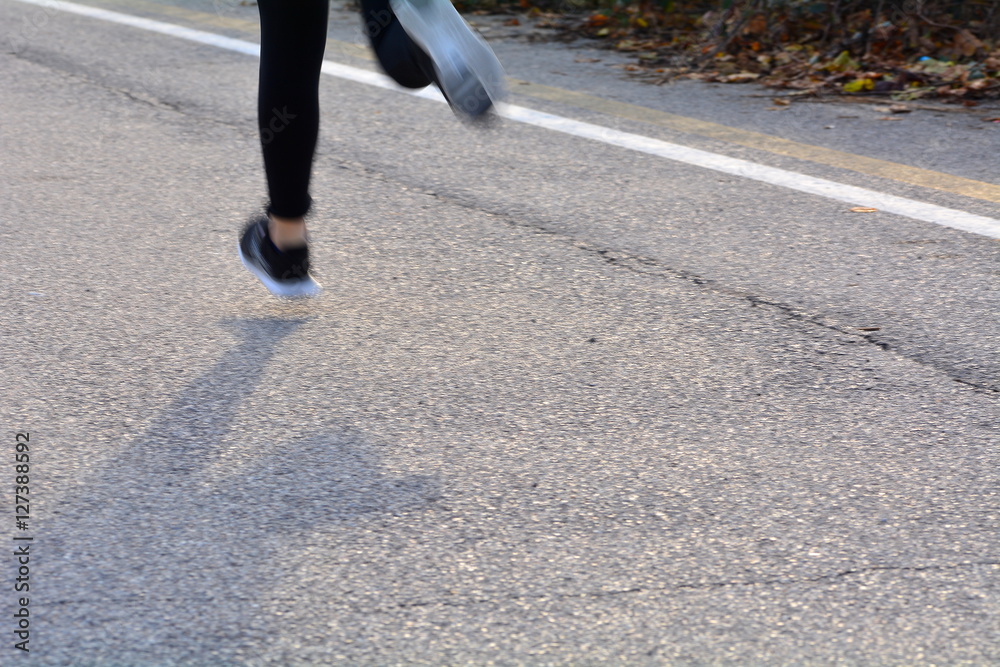 Group of runners during a race cross-country road; motion blur to highlight the speed effect Group of runners during a race cross-country road; motion blur to highlight the speed effect