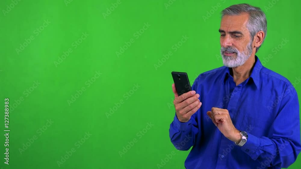 old senior man works (typing) on smartphone - green screen - studio old senior man works (typing) on smartphone - green screen - studio