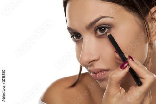 young woman applied eyeliner.
