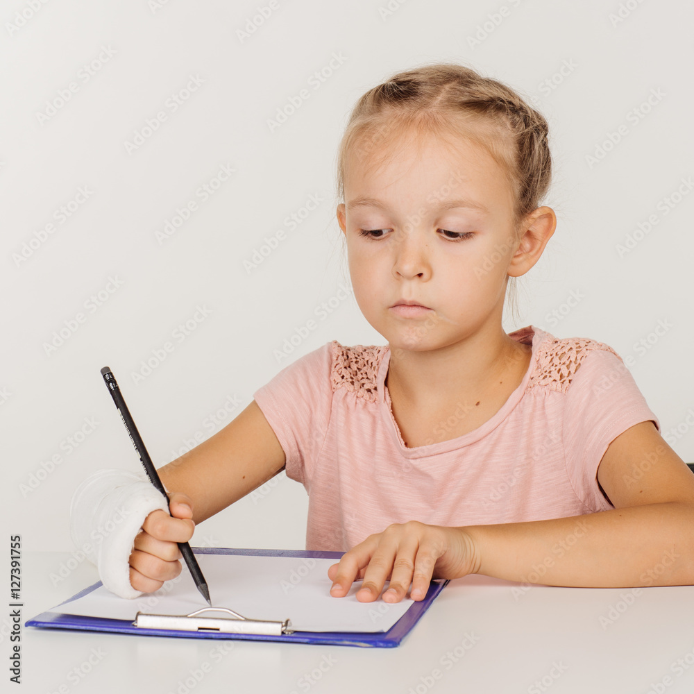 little girl with broken arm is sitting at the table little girl with broken arm is sitting at the table