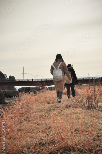 travelers with backpacks walking through golden field