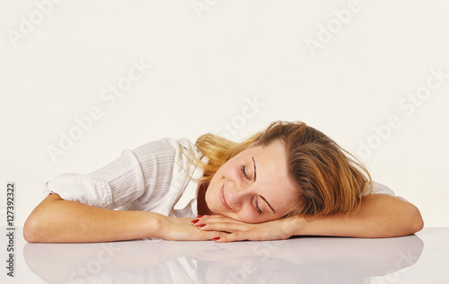 Overworked and tired young woman sleeping on des