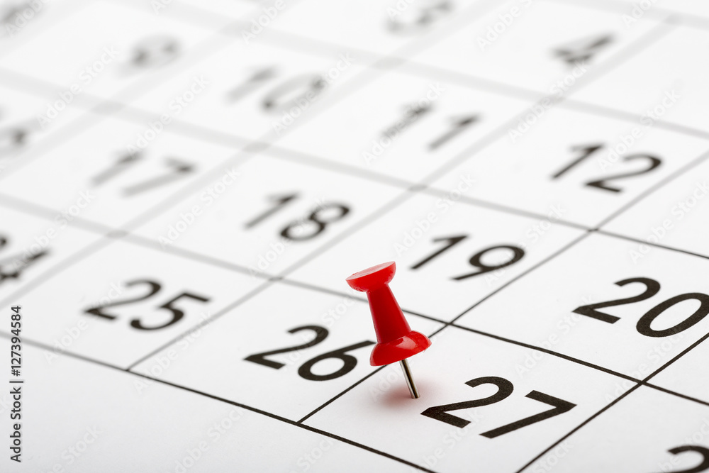Pin on the date number 27. The twenty seventh day of the month is marked with a red thumbtack. Focus point on the red pin. Pin on the date number 27. The twenty seventh day of the month is marked with a red thumbtack. Focus point on the red pin.