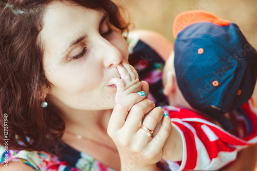 happy mommy kiss hands of her beloved little son