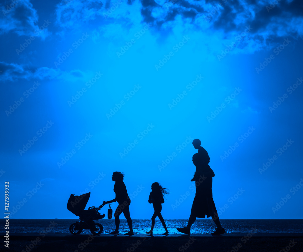 Silhouette of family walking on the beach with mother pushing baby cart   with color filter effected