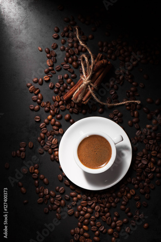 Принти на полотні Fresh tasty espresso cup of hot coffee with coffee beans on dark