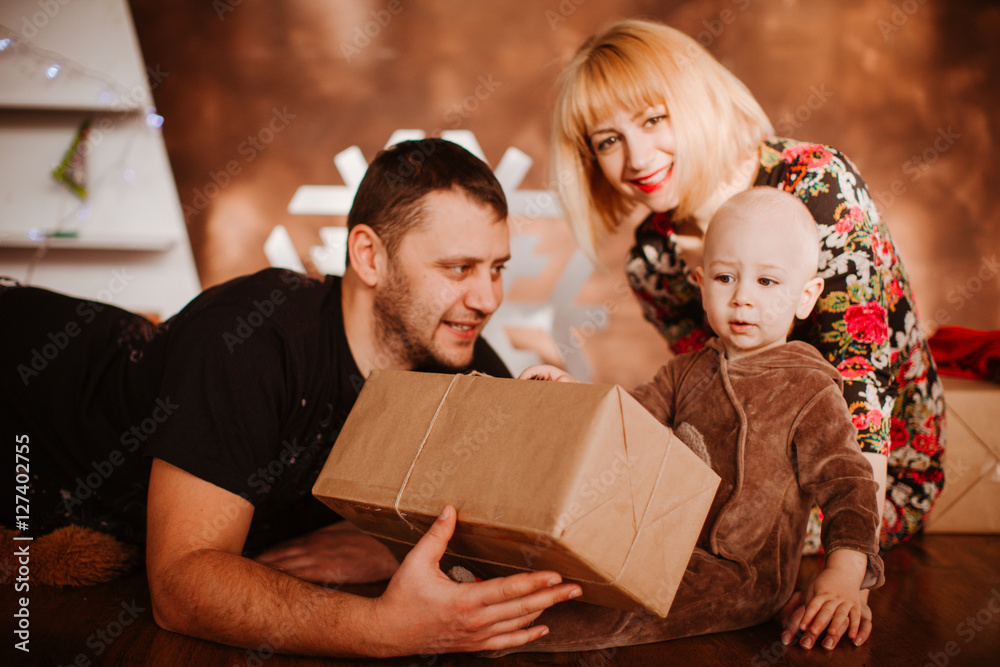 father giving a gift to his son sitting on floor father giving a gift to his son sitting on floor