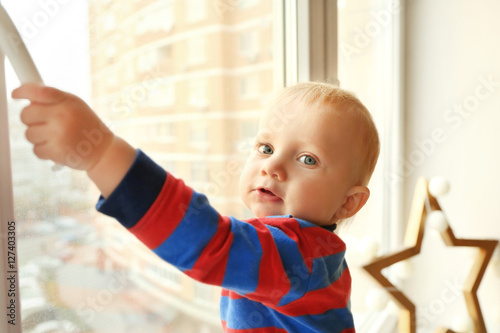 Cute little boy near window...