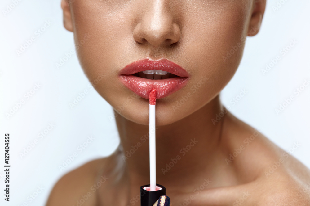 Beauty Makeup. Beautiful Woman Applies Lip Gloss - obrazy, fototapety, plakaty 