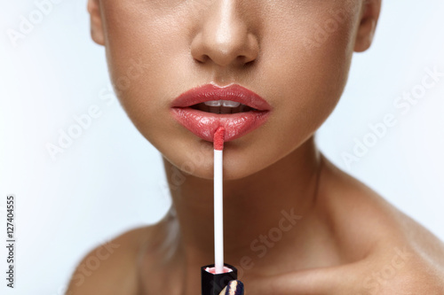 Fotografie Beauty Makeup. Beautiful Woman Applies Lip Gloss