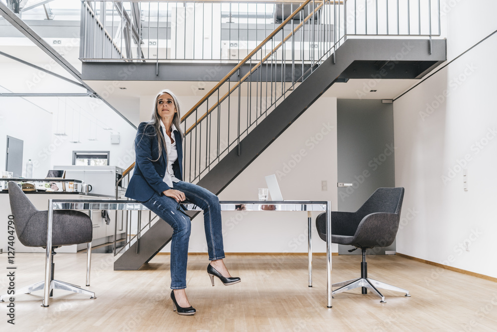 Businesswoman with long grey hair in office Businesswoman with long grey hair in office
