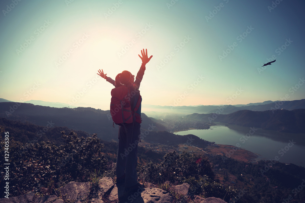 successful woman backpacker on beautiful mountain top