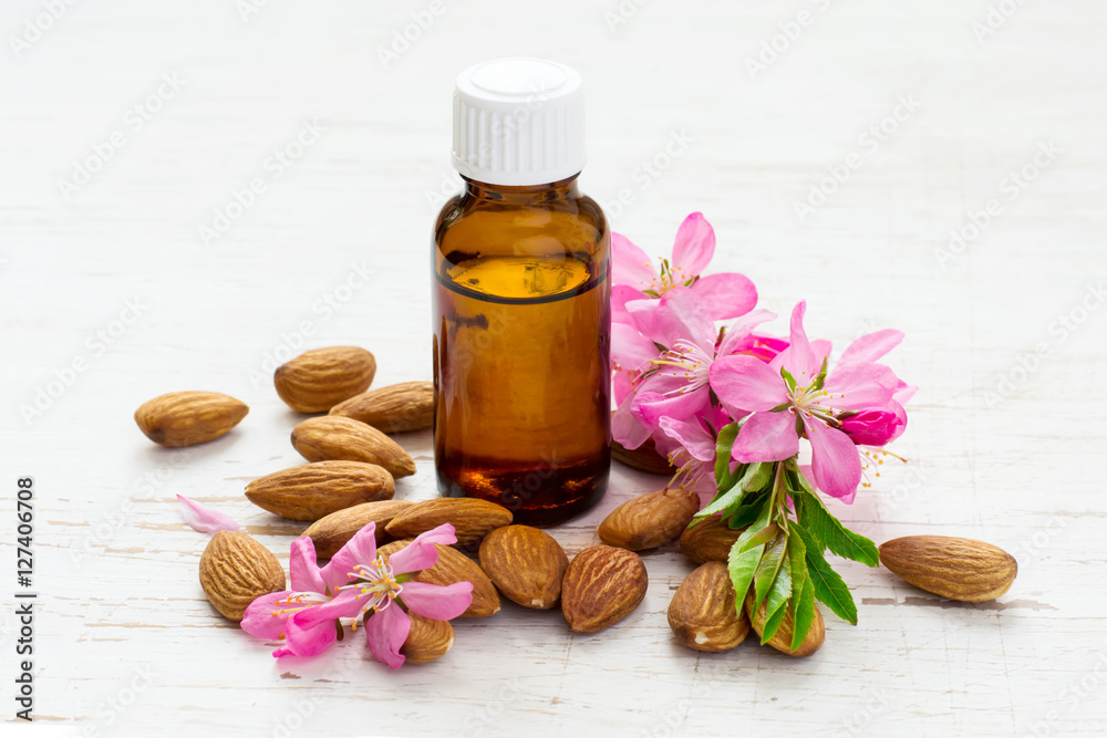 small bottle of almond oil, almonds and flowers small bottle of almond oil, almonds and flowers