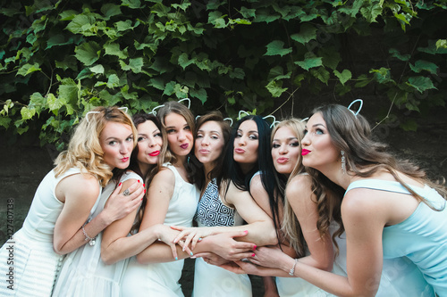 The future bride with girls stand near trees