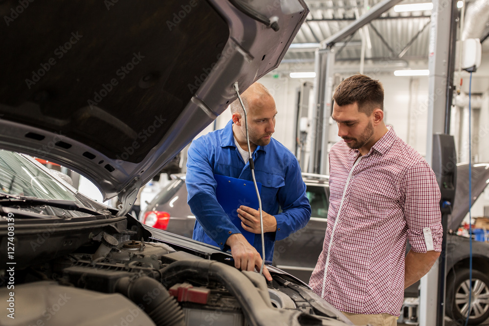auto mechanic with clipboard and man at car shop auto mechanic with clipboard and man at car shop